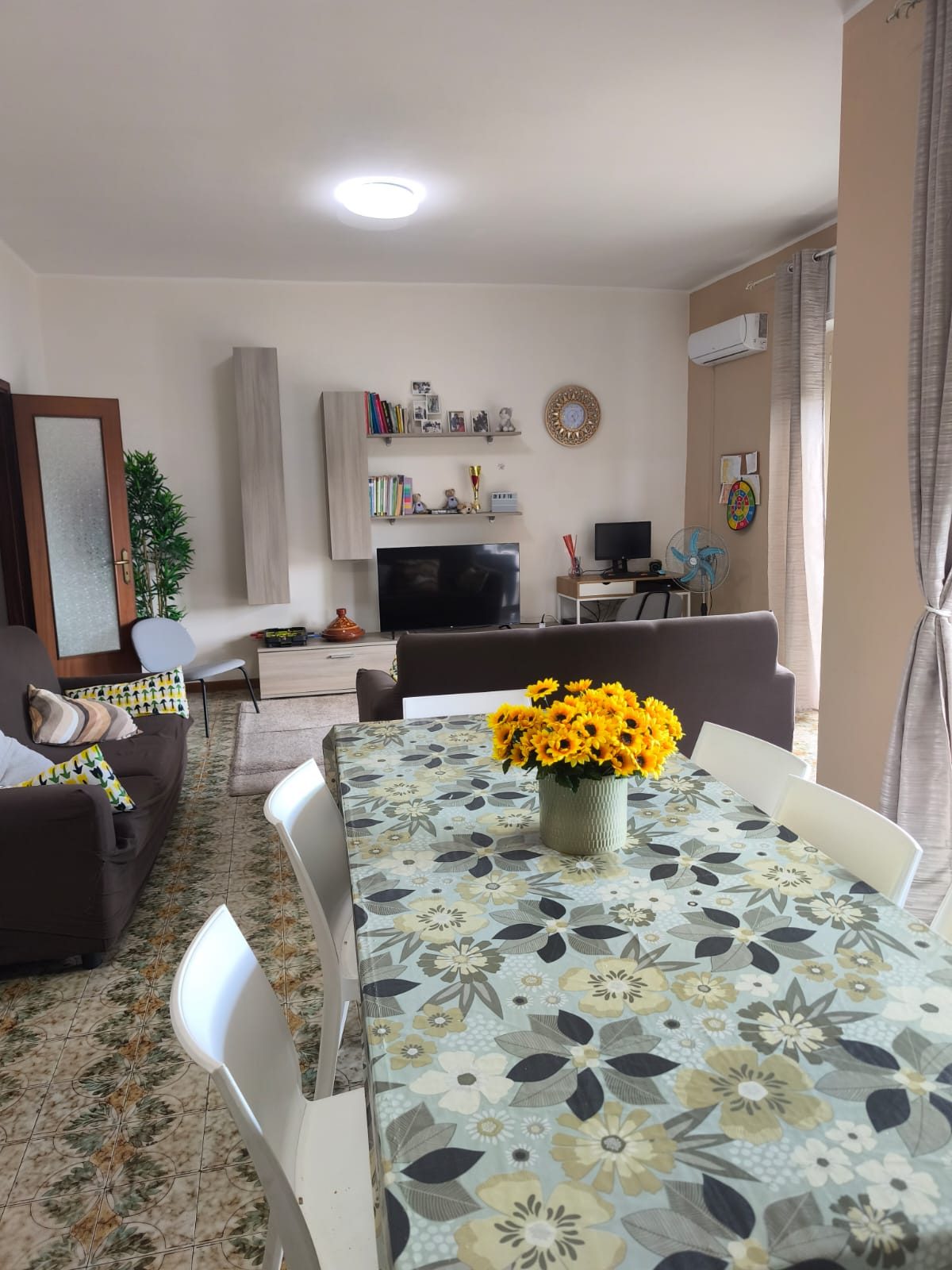 Salotto visto dall’angolo pranzo con libreria e TV nella comunità CPA Futura