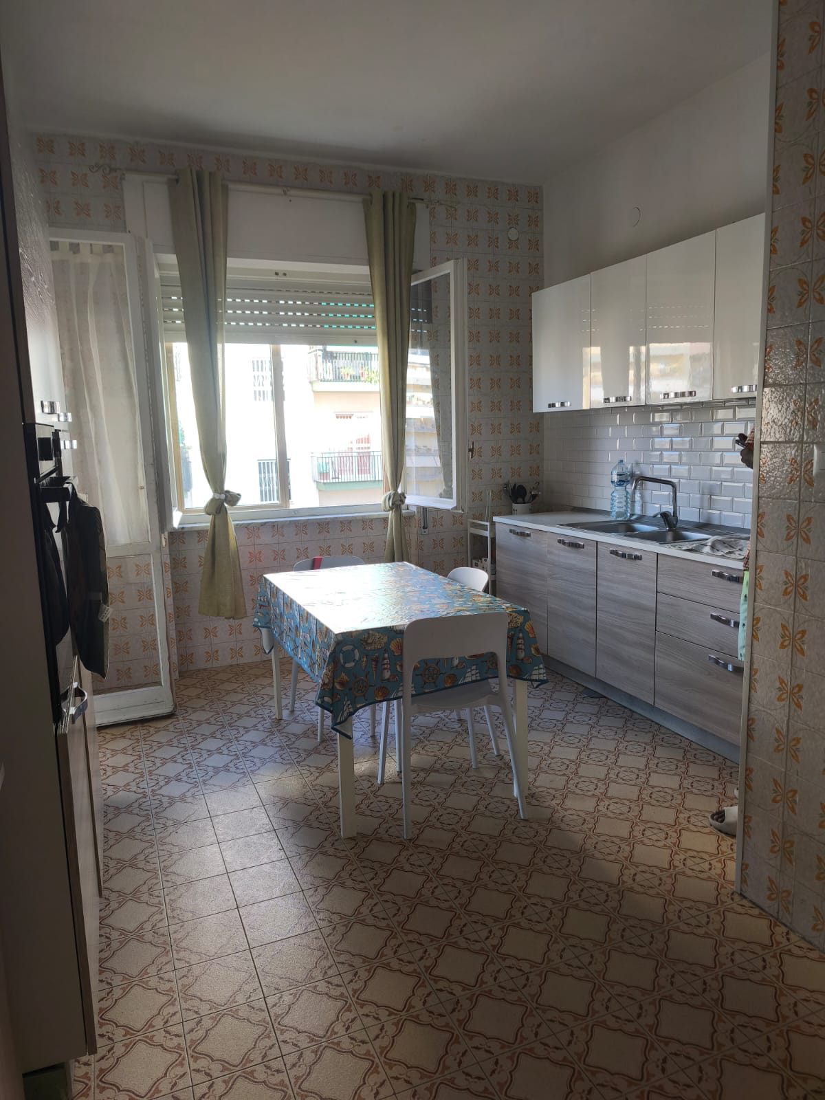 Cucina con tavolo apparecchiato e vista sul balcone nella comunità CPA Futura