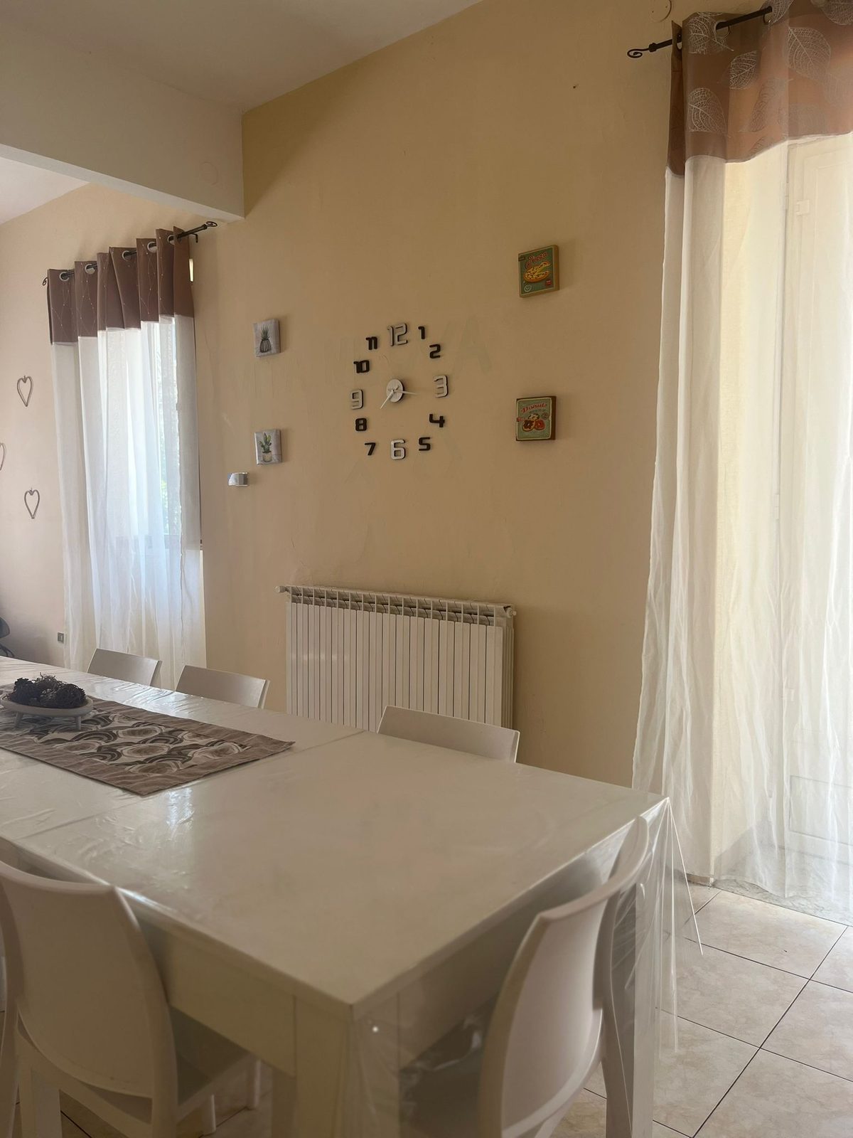 Sala da pranzo con tavolo e orologio a parete nella comunità Happy Family