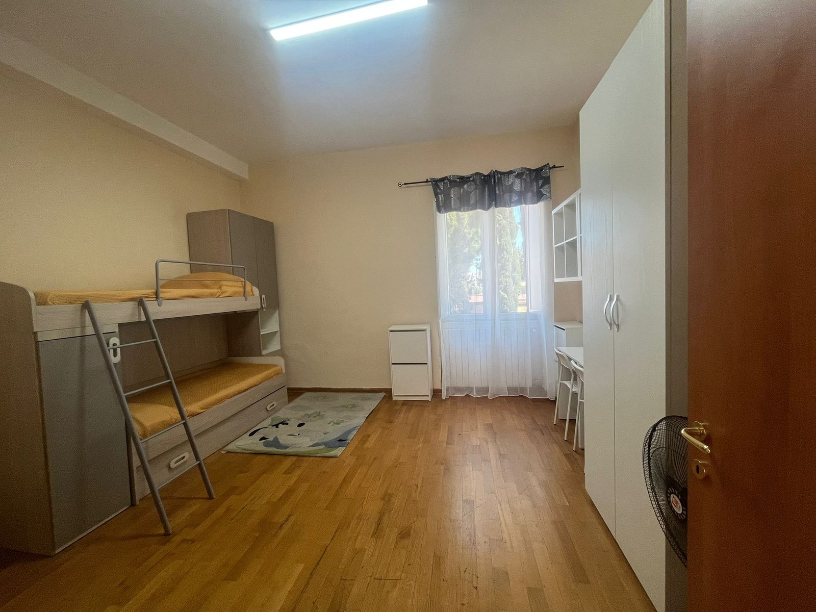 Cameretta con letto a castello, scrivania e armadio nella comunità Happy Family