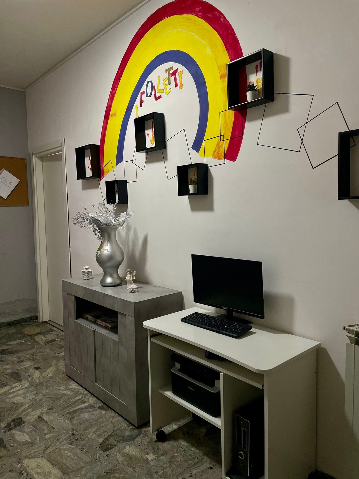 Corridoio con murale arcobaleno “I Folletti” e postazione computer