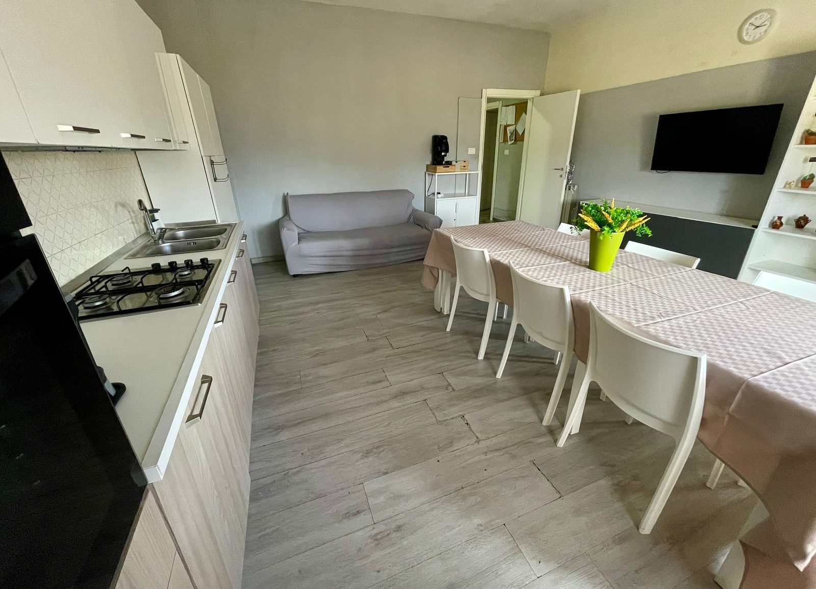 Cucina open space con divano, tavolo da pranzo e TV nella comunità I Folletti
