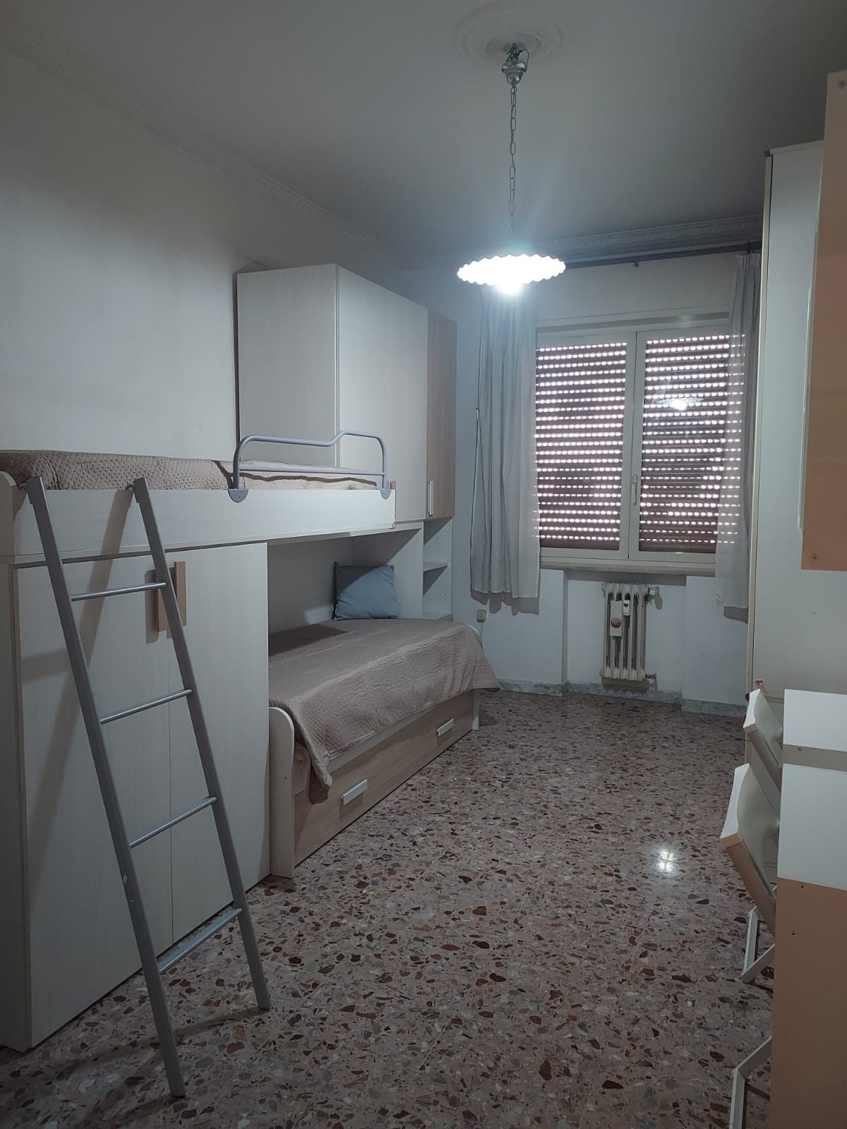 Camera con letto a castello e finestra con persiane nella comunità La Casa di Nonna Pupetta