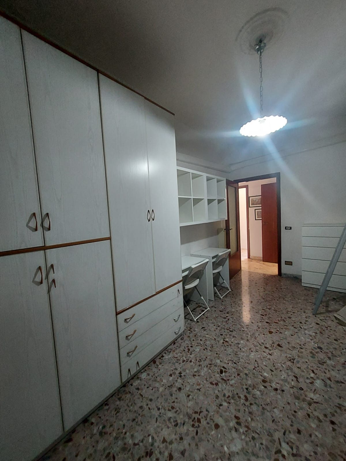 Camera con armadio bianco, scrivania e libreria nella comunità La Casa di Nonna Pupetta