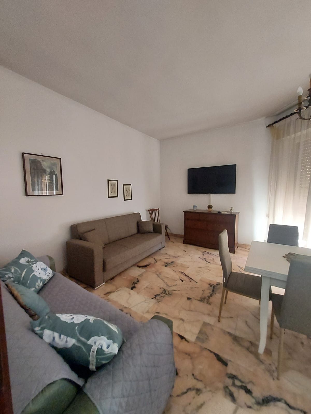Soggiorno con divani e TV nella comunità La Casa di Nonna Pupetta